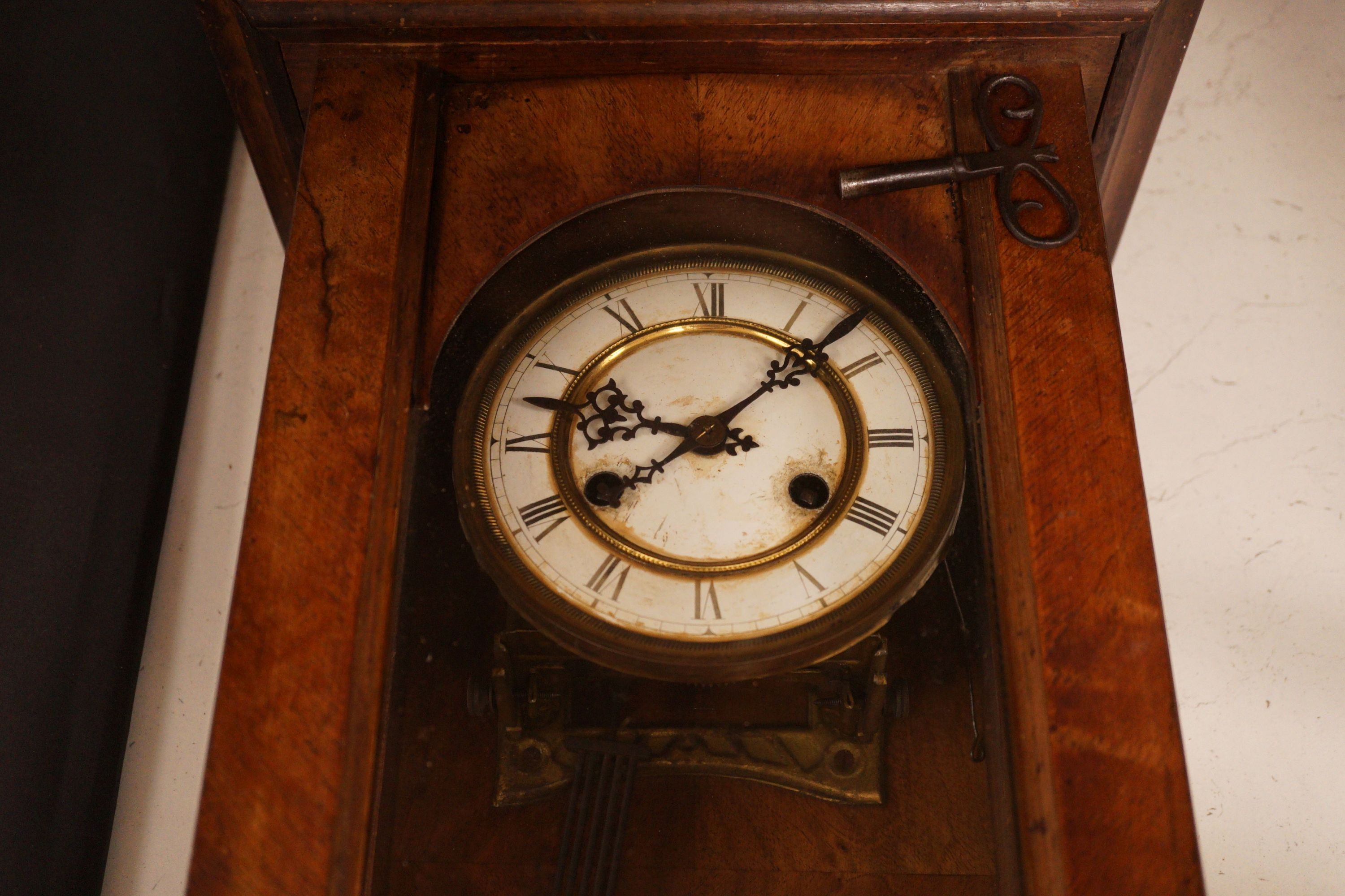 A small German wall clock with key, 58cm